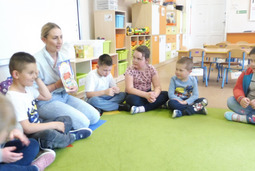 Mama Oskara czyta dzieciom bajkę "Wilk i siedem koźlątek".